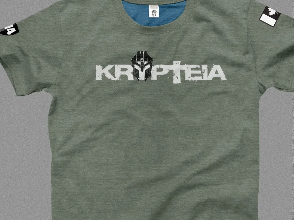 Heather grey t-shirt printed with the Krypteia wordmark, the mask set into the Y, and a Canadian flag on the sleeve
