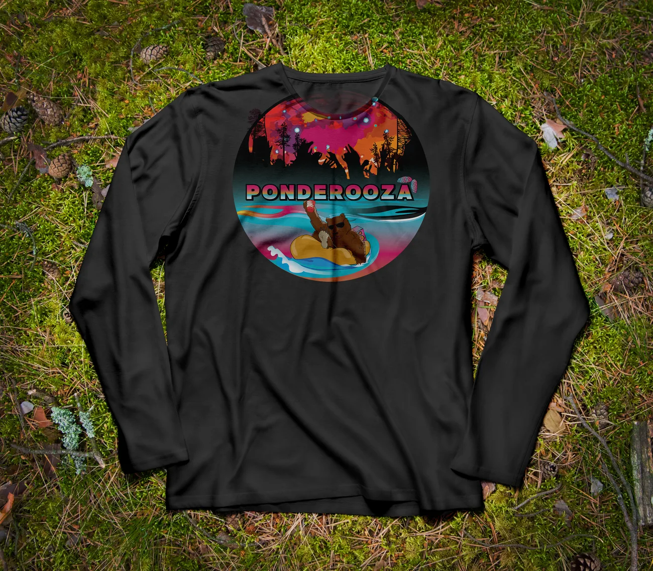 Black longsleeve shirt laid on grass, printed with the circular sunset badge