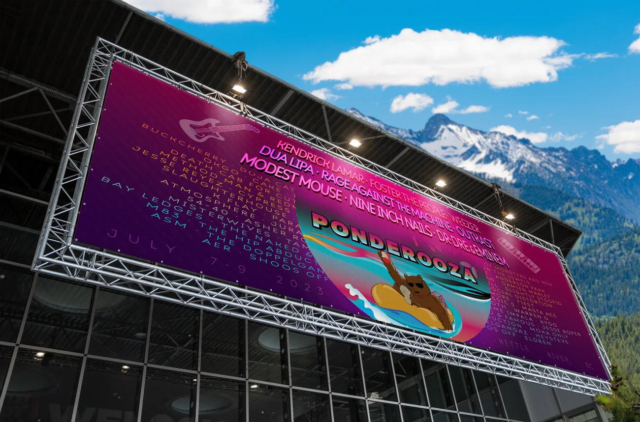 Large festival banner mounted on scaffolding against a mountain backdrop