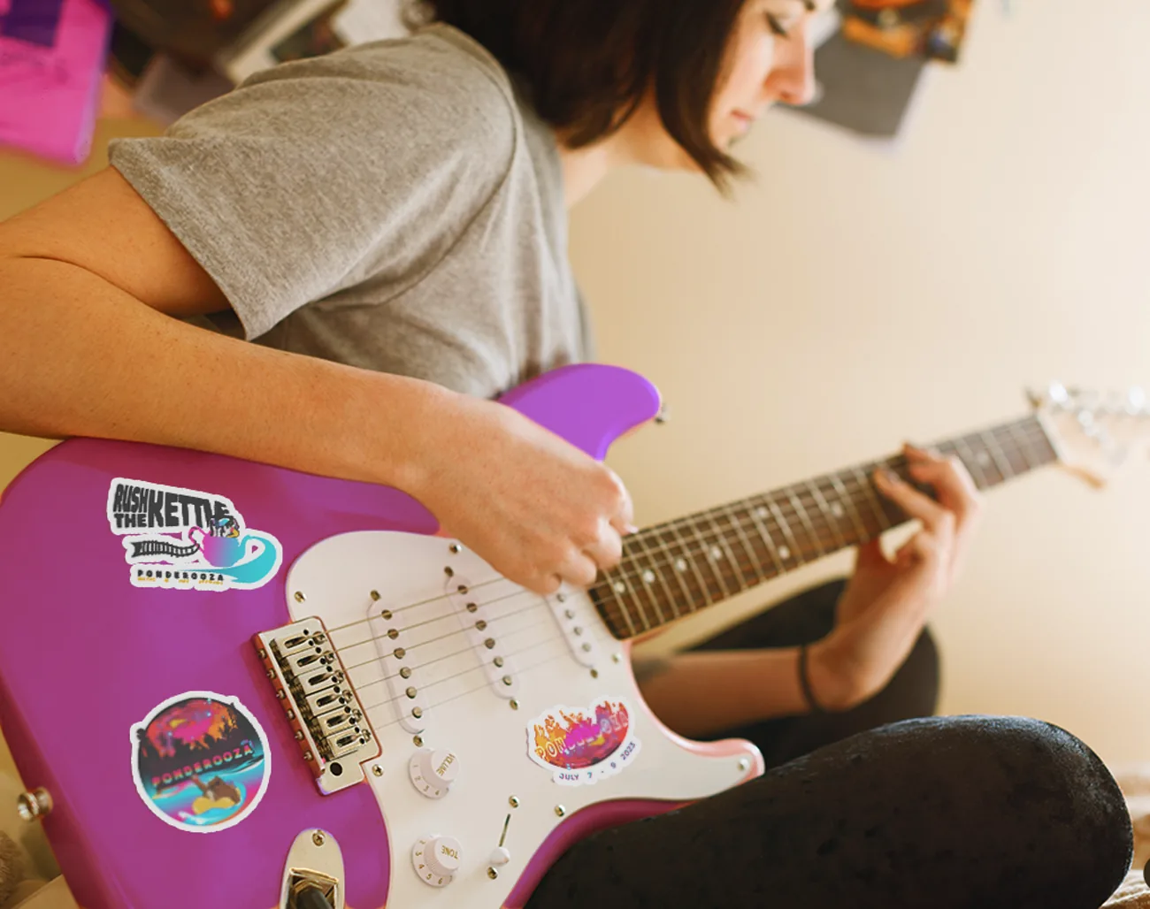 Ponderooza stickers applied to the body of an electric guitar being played