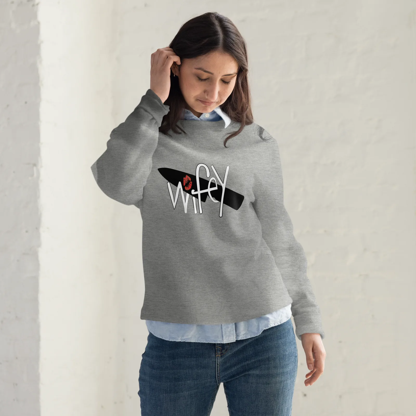Woman wearing a heather grey crew neck sweatshirt printed with the Wifey submark across the chest