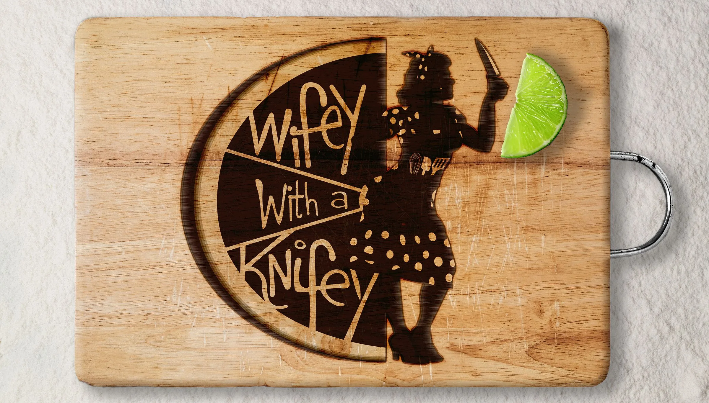 The Wifey with a Knifey mark branded into a wooden cutting board, the hand-lettered name filling a lime slice with the mascot stepping out of it, a lime wedge resting on the board